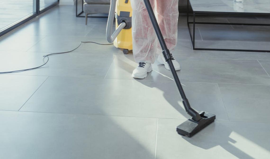 Person in hazmat suit steam cleaning floor