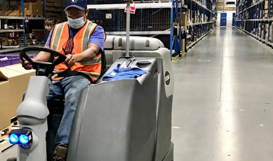 Person cleaning warehouse floor